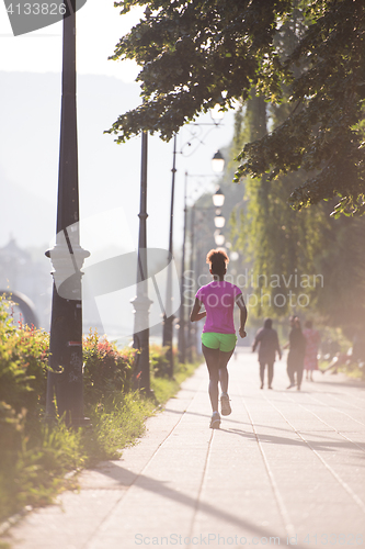 Image of african american woman jogging in the city