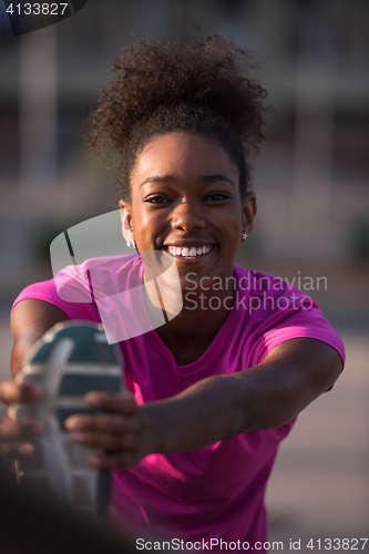 Image of African American woman doing warming up and stretching