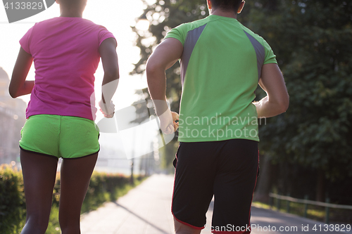 Image of young multiethnic couple jogging in the city