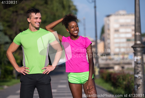 Image of portrait of young multietnic jogging couple ready to run