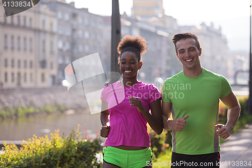 Image of young multiethnic couple jogging in the city