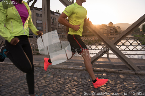 Image of young multiethnic couple jogging in the city