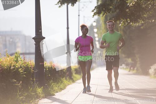 Image of young multiethnic couple jogging in the city