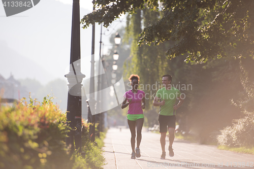 Image of young multiethnic couple jogging in the city