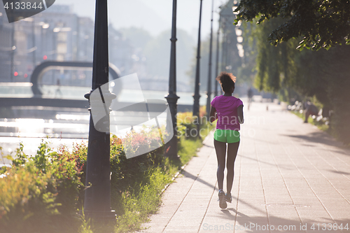 Image of african american woman jogging in the city