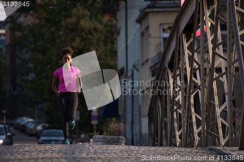 Image of african american woman running across the bridge