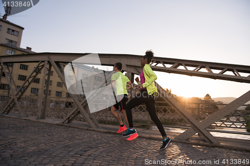 Image of young multiethnic couple jogging in the city