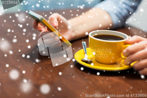 Image of woman with smartphone drinking coffee at cafe