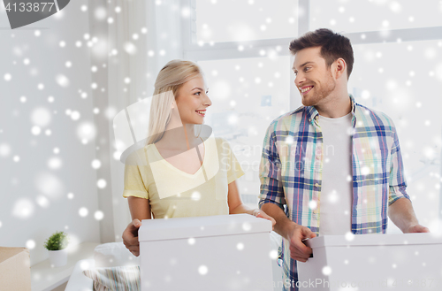 Image of smiling couple with big boxes moving to new home