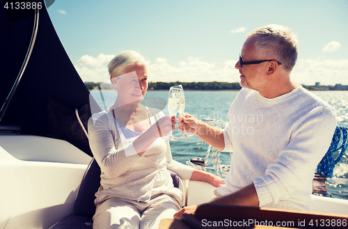 Image of senior couple clinking glasses on boat or yacht