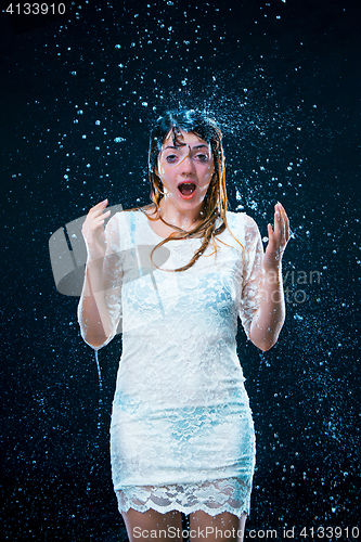 Image of The young girl standing under running water