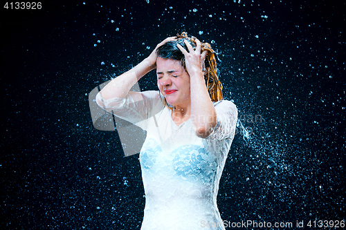 Image of The young girl standing under running water