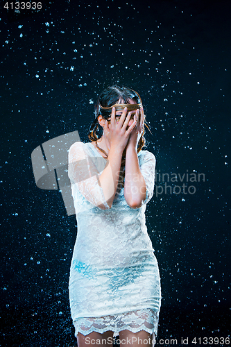 Image of The young girl standing under running water