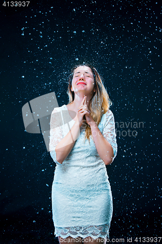 Image of The young girl standing under running water