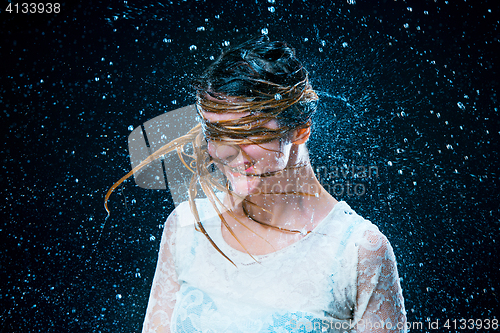 Image of The young girl standing under running water