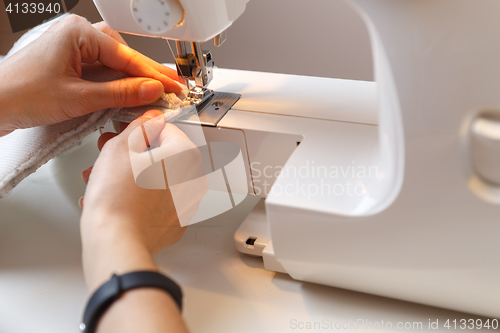 Image of Girl makes stitch on sewing-machine