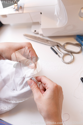 Image of Woman works with white cloth