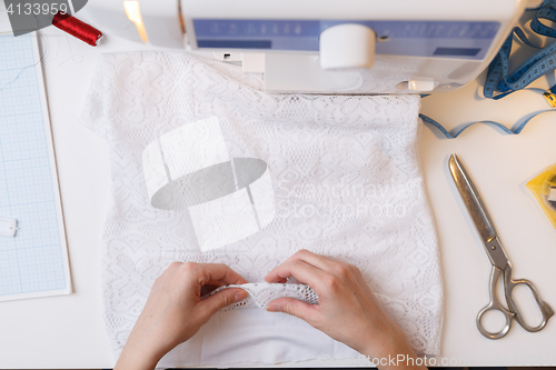 Image of Seamstress prepares fabric for sewing