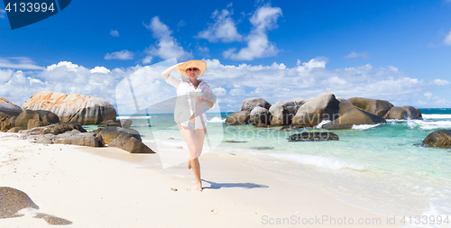 Image of Woman enjoying white sandy beach on Mahe Island, Seychelles.