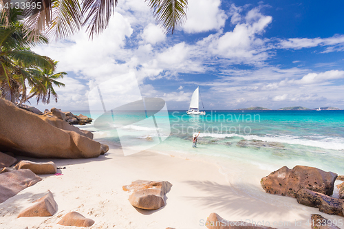 Image of Woman enjoying Anse Patates picture perfect beach on La Digue Island, Seychelles.