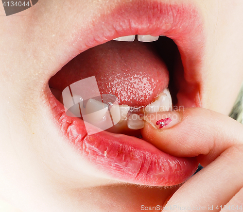 Image of Closeup of finger feeling a lose tooth in a little girls mouth