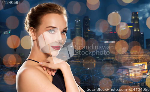 Image of beautiful woman in black over dark background