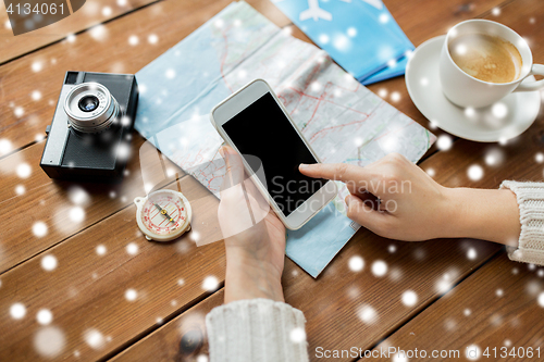 Image of close up of traveler hands with smartphone and map