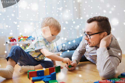 Image of father and son playing with toy blocks at home
