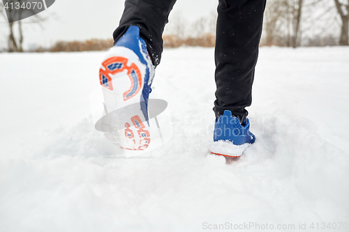 Image of close up of feet running along snowy winter road