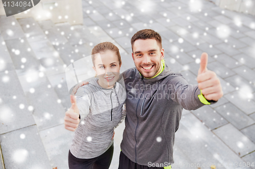 Image of couple of sportsmen showing thumbs up outdoors