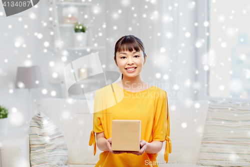 Image of happy asian young woman with parcel box at home