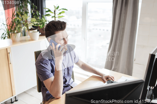 Image of happy creative male worker calling on smarphone