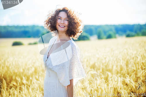 Image of beautiful woman in a white dress in a wheat field