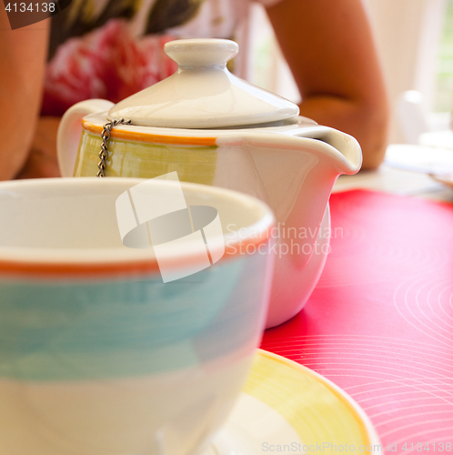 Image of kettle for making tea and cups in cafe