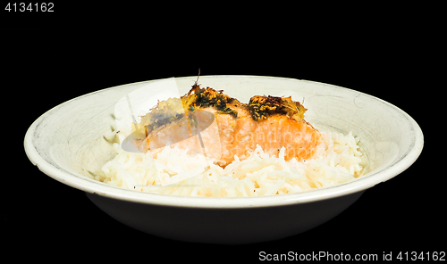 Image of Delicious piece of salmon on a bed of long grained rice, in a de