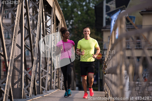 Image of multiethnic couple jogging in the city