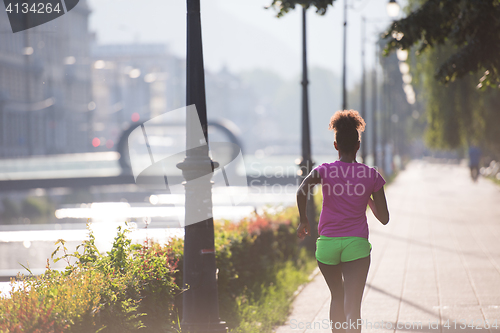 Image of african american woman jogging in the city