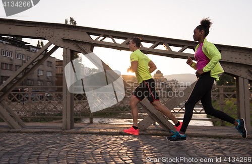 Image of young multiethnic couple jogging in the city
