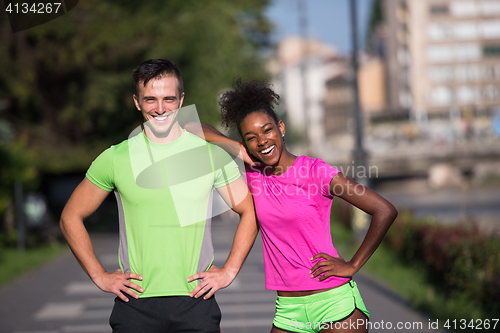 Image of portrait of young multietnic jogging couple ready to run