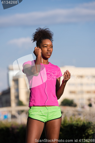 Image of young african american woman running outdoors