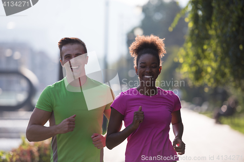 Image of young multiethnic couple jogging in the city