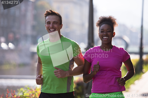 Image of young multiethnic couple jogging in the city