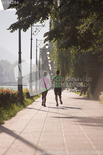 Image of young multiethnic couple jogging in the city