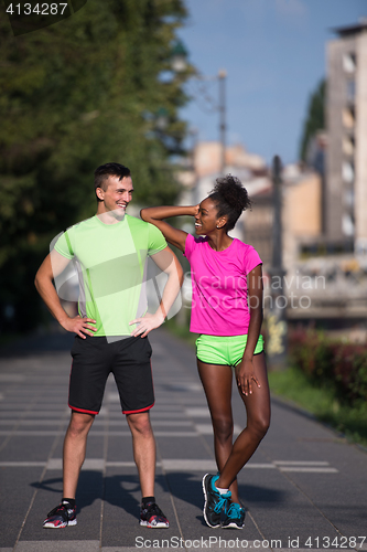 Image of portrait of young multietnic jogging couple ready to run