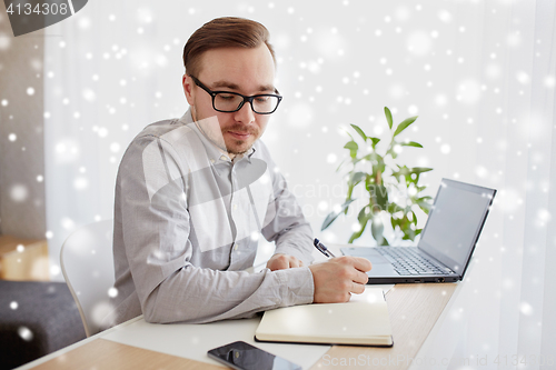 Image of creative man or businessman writing to notebook