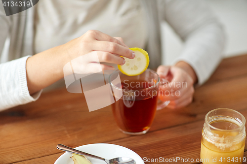 Image of close up of ill woman drinking tea with lemon