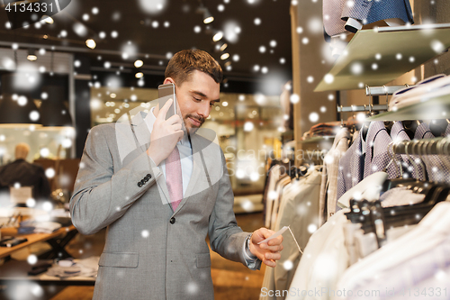 Image of happy man calling on smartphone at clothing store