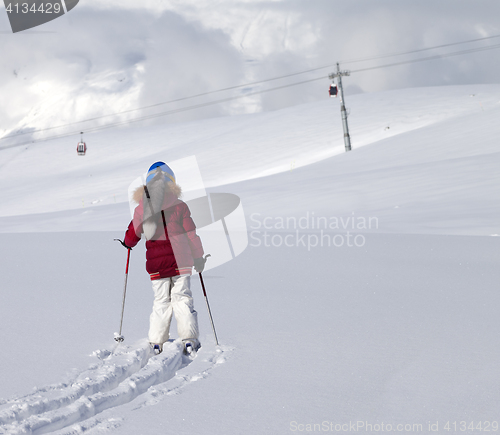 Image of Girl on skis in off-piste slope with new fallen snow at nice day