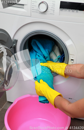 Image of woman hands in gloves holding clothes