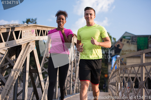 Image of multiethnic couple jogging in the city